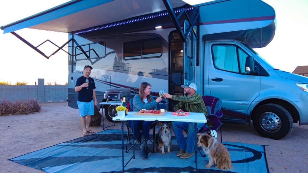 Three friends with a dog and an RV.