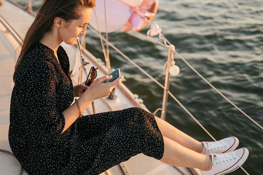 A woman on her phone on a boat.